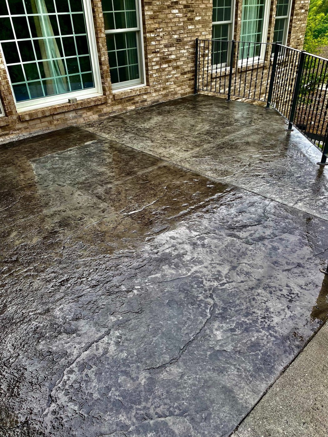 Gray slate stamped concrete patio against a brick home